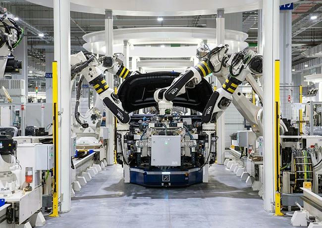 Close-up industrial photograph of a robust pneumatic automatic riveting machine clenching a brake pad to a metallic bracket in a modern automated automotive production line, emphasizing precision and zero deformation.